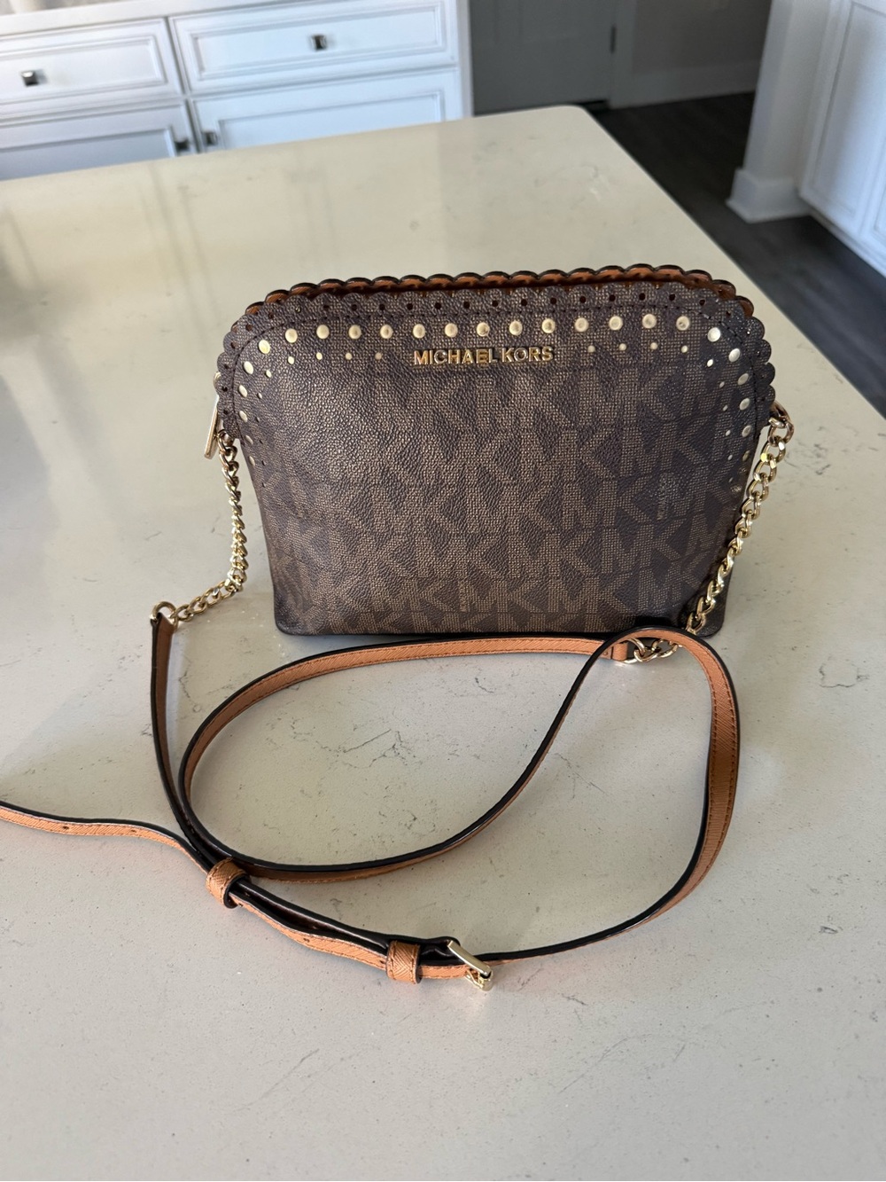 This is a Michael Kors Jet Set-style crossbody bag in the brown MK Signature log
